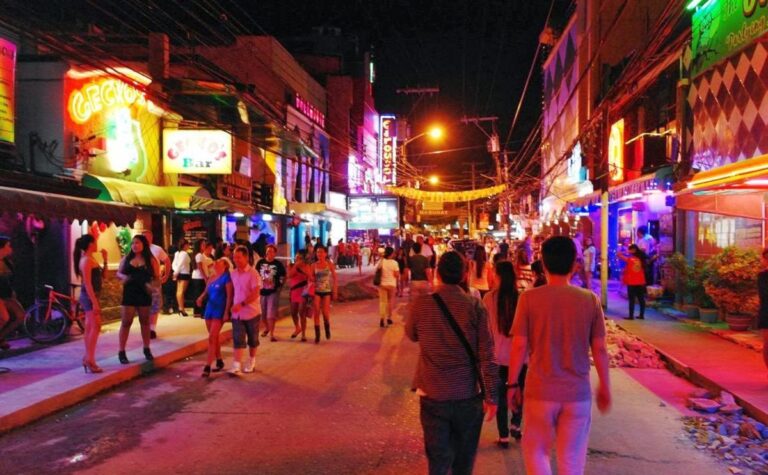 Nightlife in Angeles City with neon lights and people socializing outdoors