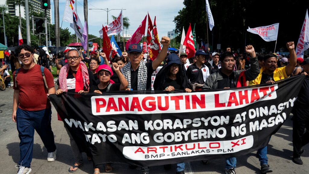 Crowd of protesters along EDSA in Manila holding banners against flood-control corruption