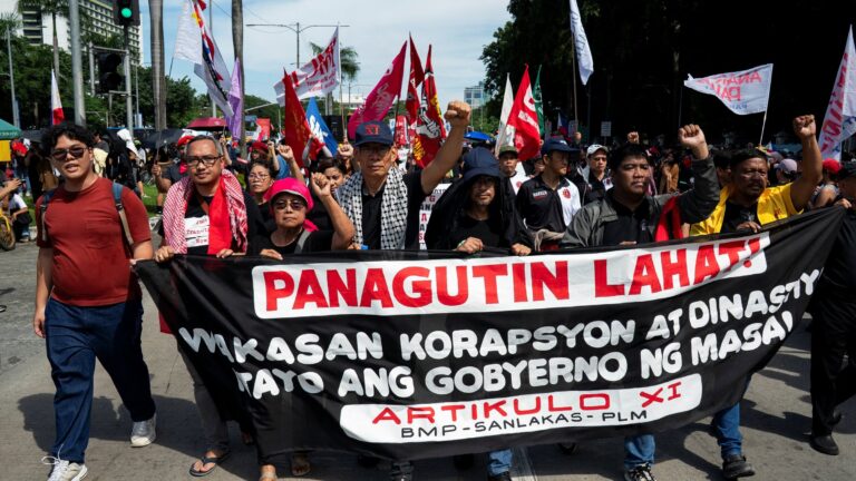 Crowd of protesters along EDSA in Manila holding banners against flood-control corruption